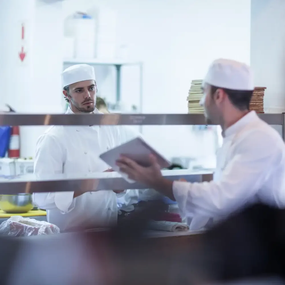 chefs-discussing-orders-in-kitchen-2025-04-04-19-55-58-utc